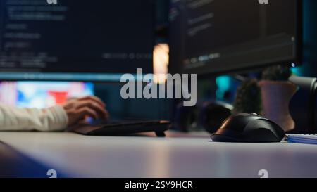 Computer technician working from home, designing and developing software applications, close up. IT specialist typing on PC keyboard, implementing and maintaining company systems, camera B Stock Photo