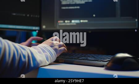 Technician doing software quality assurance, reading source code on PC before implementing it. IT admin inspecting coding on computer, looking to fix potential issues, camera B close up Stock Photo