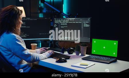 Programmer using green screen laptop to secure company servers from virus attacks. IT remote employee writing code, building firewalls protecting data using mockup notebook, camera B Stock Photo