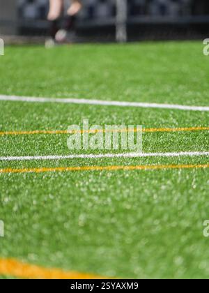 Detailed shot of a green soccer field with clearly marked white and yellow lines in focus, creating a vibrant and textured background, ideal for footb Stock Photo