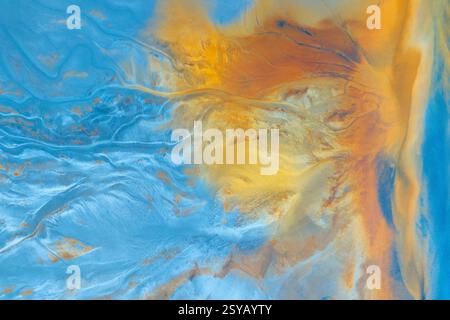 This image features an abstract aerial view of a landscape, showcasing a vibrant blend of blue and orange hues that create a dynamic, textured appeara Stock Photo