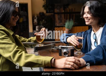 A couple enjoys each other's company over drinks at an outdoor cafe. They are relaxed and smiling, capturing a moment of leisure and happiness. Stock Photo