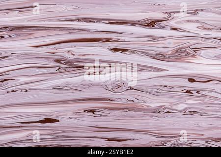 A mesmerizing marbled texture featuring swirling patterns of brown and pink acrylic paint hues. The fluid dynamics create a captivating abstract desig Stock Photo