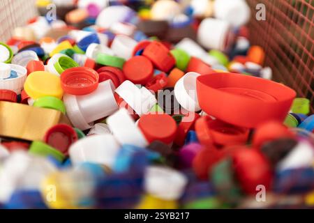 A vibrant selection of assorted plastic bottle caps piled in a basket, highlighting recycling and environmental efforts. Stock Photo