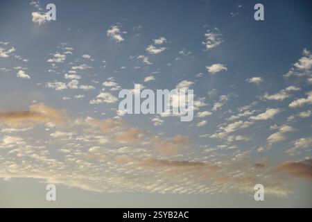 Soft scattered clouds in the sky during dusk. The pastel colors create a dreamy and tranquil atmosphere. Stock Photo