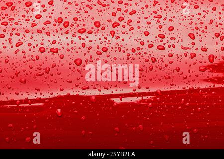 Abstract red background of wet metallic surface with raindrops Stock Photo