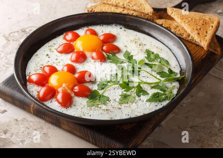 Flower fried eggs with cherry tomatoes and parsley  close-up on plate on table. Funny food. Horizontal Stock Photo