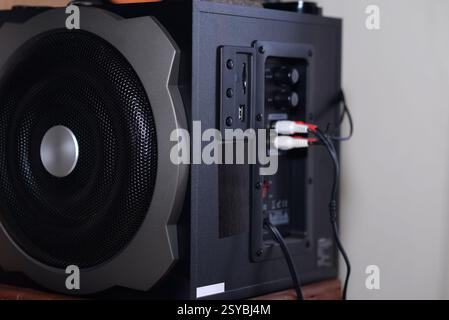 The image shows a detailed view of a black speaker, highlighting its side panel with various input options. The speaker has a large mesh-covered drive Stock Photo
