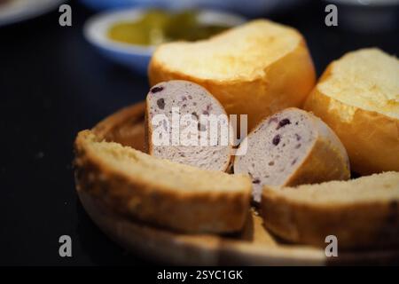 Slices of bread in a wooden plate on a black background Stock Photo
