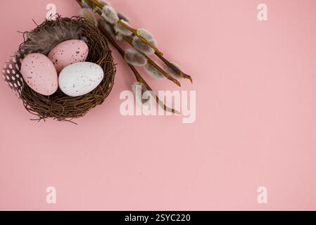 Easter eggs in a basket with willow on a pink background Stock Photo