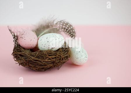 Easter eggs in a basket with willow on a pink background Stock Photo