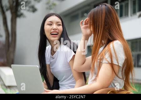 Two university students laughing and sharing ideas, promoting collaboration in education Stock Photo