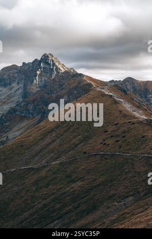 A mountain landscape under a dramatic, cloudy sky with the clouds ...
