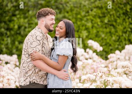 Couple embracing each other and laughing in garden Stock Photo