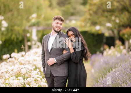 A happy couple celebrating their engagement in a garden Stock Photo