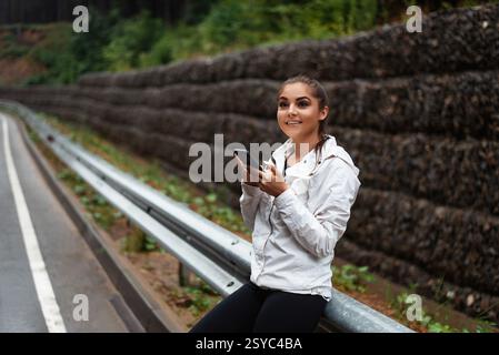 Smiling female tourist using modern cell phone outdoors Stock Photo