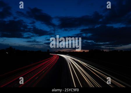 Night Highway Long Exposure with Blurred Lights and Dramatic Cloudy Sky Stock Photo