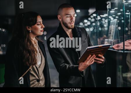 Young business professionals collaborating over a tablet in an urban environment Stock Photo