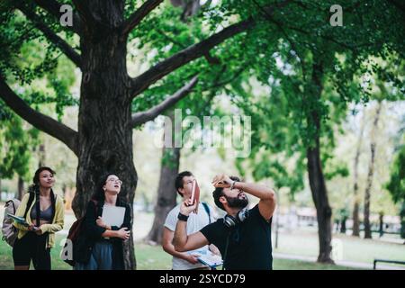 Multicultural students working on assignments in a serene park environment Stock Photo
