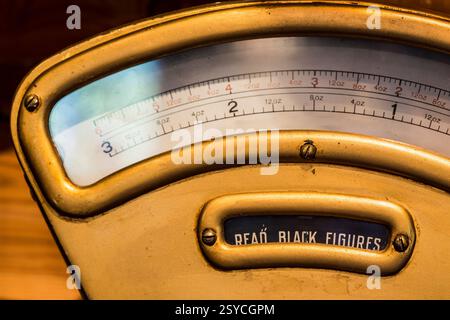 Vintage scale with a black figure on it. The scale is made of gold and has a black figure engraved on it. The figure is likely a representation of a p Stock Photo