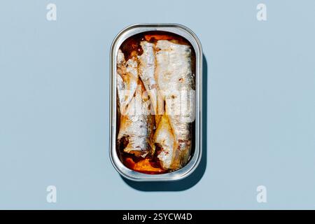 high angle view of an open can of tinned sardines placed on a light blue background Stock Photo