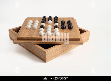 Black and white glass marble game of solitaire hand made in hardwood with box Stock Photo