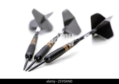 Three black darts are placed on a white background with the tips of the darts pointing in the same direction. Stock Photo