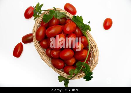 Cherry Tomatoes in a wicker basquet on white background. Stock Photo
