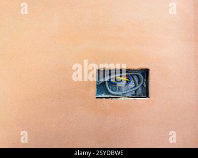 Electric socket in a hole cut in plasterboard on the walls of a house extension. No people. Copy space. Stock Photo