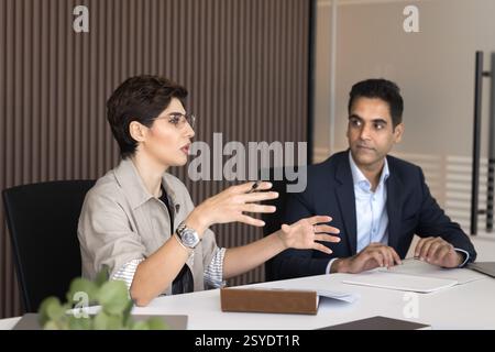 Serious stylish businesswoman speak on negotiations with partners in boardroom Stock Photo