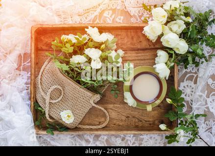 Top view of a beautiful tea table with tea cup and roses flowers, and decorations on stylish white background. Stock Photo