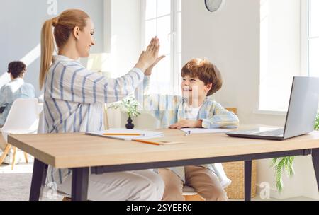 Mother Helps Son With Homework And Giving High Five Stock Photo