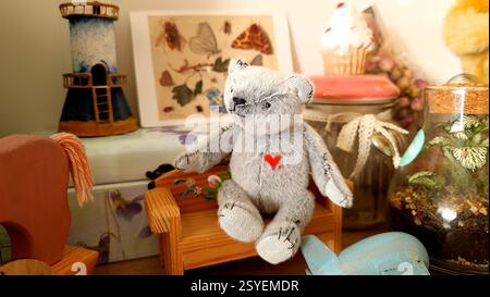Handmade teddy bear is sitting on the bench Stock Photo