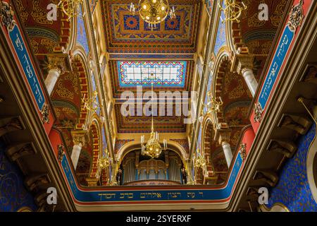A low-angle interior shot of a richly decorated space featuring an ornate ceiling with a skylight, surrounded by arched sections, intricate patterns, Stock Photo