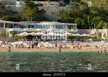 Banje Beach & tourists, with the Banje restaurant cafe. Beach is situated in front of Ploče Gate, the eastern entrance to the Old Town. Dubrovnik. Croatia. (138) Stock Photo