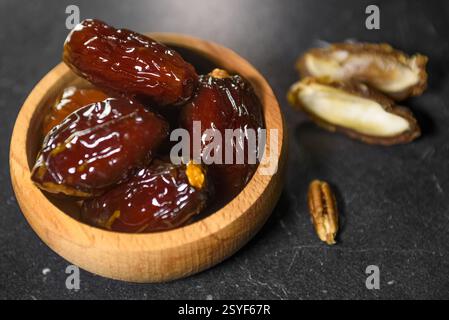 Traditional Ramadan Dates in Wooden Bowl on Black Background Stock Photo
