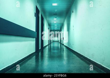 Long empty corridor washed in bluish depressive light, good as depressive photography location Stock Photo