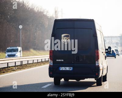 Paris, France - Feb 18, 2025: A black UPS delivery van is driving on a highway, surrounded by other vehicles under bright daylight, ensuring fast and Stock Photo
