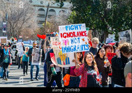 Participants march on I Street with a 'Fight Ignorance Not Immigrants' sign at the conclusion of the Pro-Immigrant Protest event, held in downtown. Stock Photo
