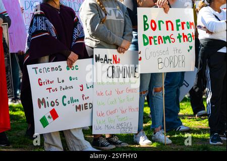Three young women hold pro-immigration signs at the Pro-immigrant Protest in downtown at Cesar Chavez park. Stock Photo