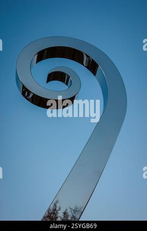 Stainless steel spiral sculpture by Roberto Pellegrinuzzi against blue sky, Le Cerisier Centre, Parc national du Mont-Orford, Quebec, Canada. Stock Photo