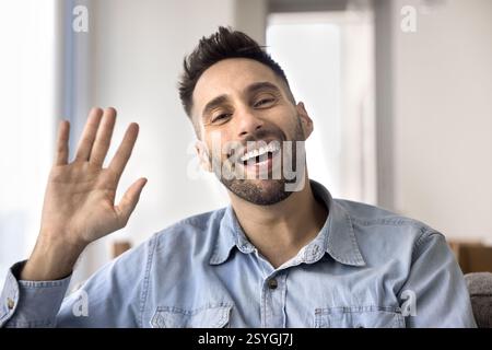 Webcam shot man greeting friend engaged in virtual meeting Stock Photo