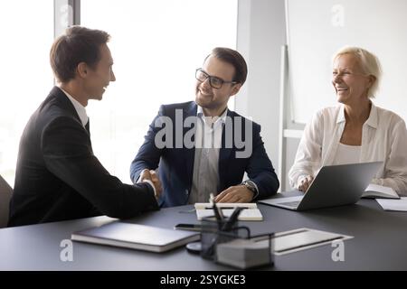 Two hr managers recruit applicant confirm successful placement with handshaking Stock Photo