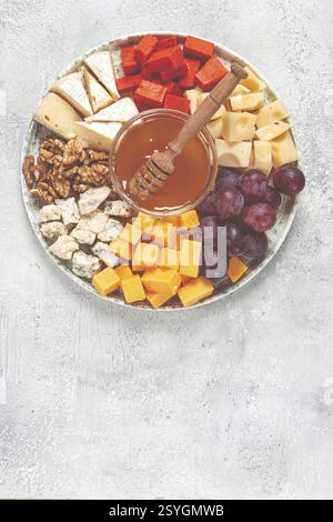 Appetizer, assorted cheese, with nuts and honey, on a round plate, top view, no people Stock Photo