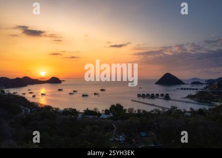 Enjoy a stunning sunset view that stretches across a tranquil sea, where silhouetted islands and boats come together to create an incredibly picturesq Stock Photo