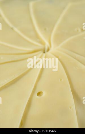 Semi-hard cheese close-up, thin slices. Stock Photo