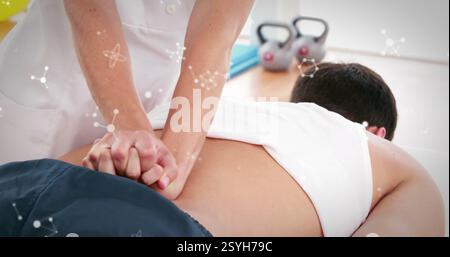 Image of molecules over caucasian female physiotherapist with patient Stock Photo