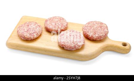 Many uncooked patties on wooden board against white background Stock Photo