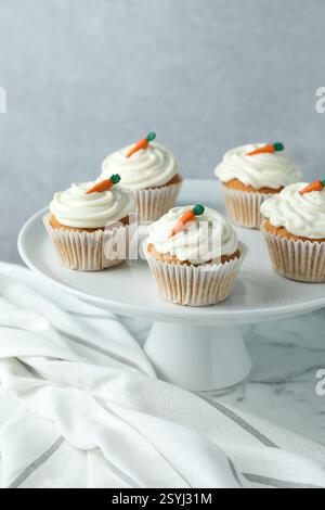 Delicious carrot cupcakes on white marble table against grey background Stock Photo