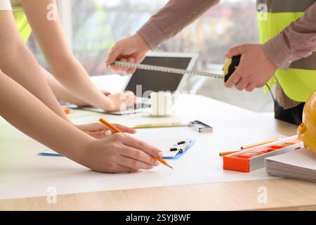 Team of constructors working at table in room, closeup Stock Photo